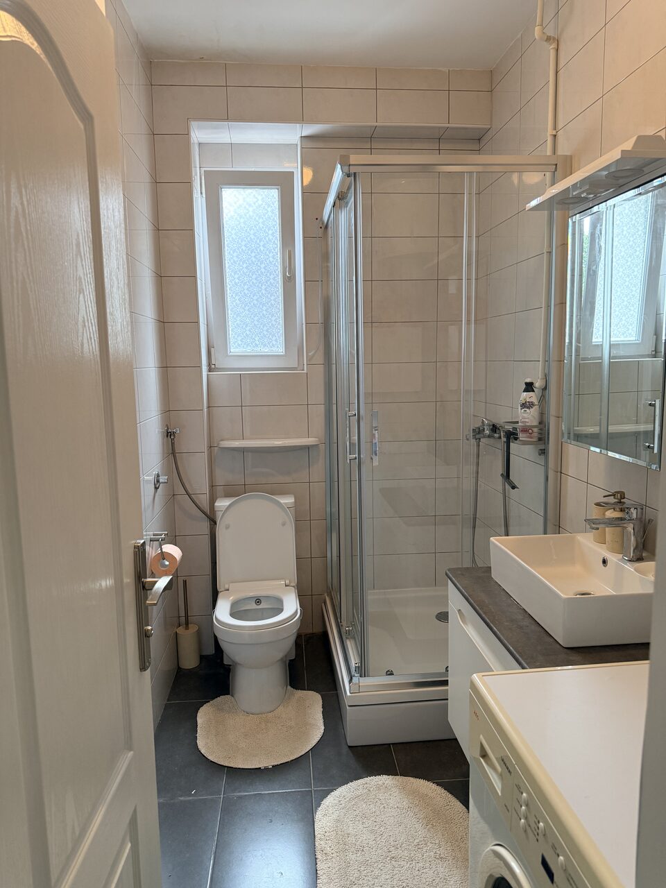 Bathroom with walk-in shower, washbasin and washing machine